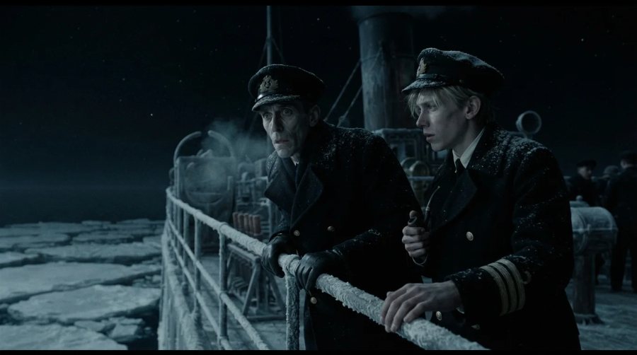 Two officers at the rail of a ship at night, looking out over the ice